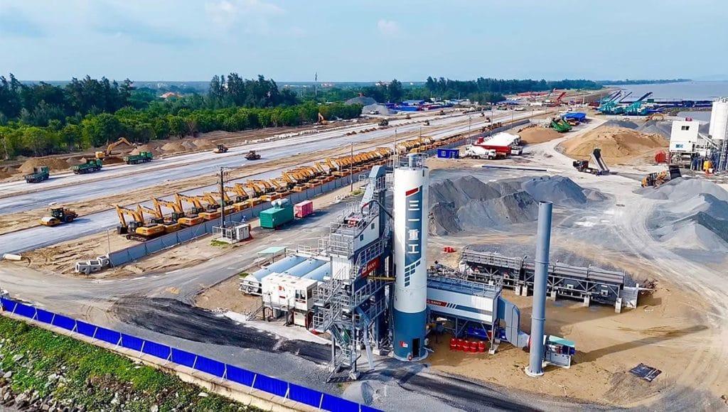 Dây chuyền trạm trộn bê tông, máy xúc, xe ben và các thiết bị xây dựng bố trí dọc khu vực san lấp, tạo nền móng cho hạ tầng khu đô thị ven biển.